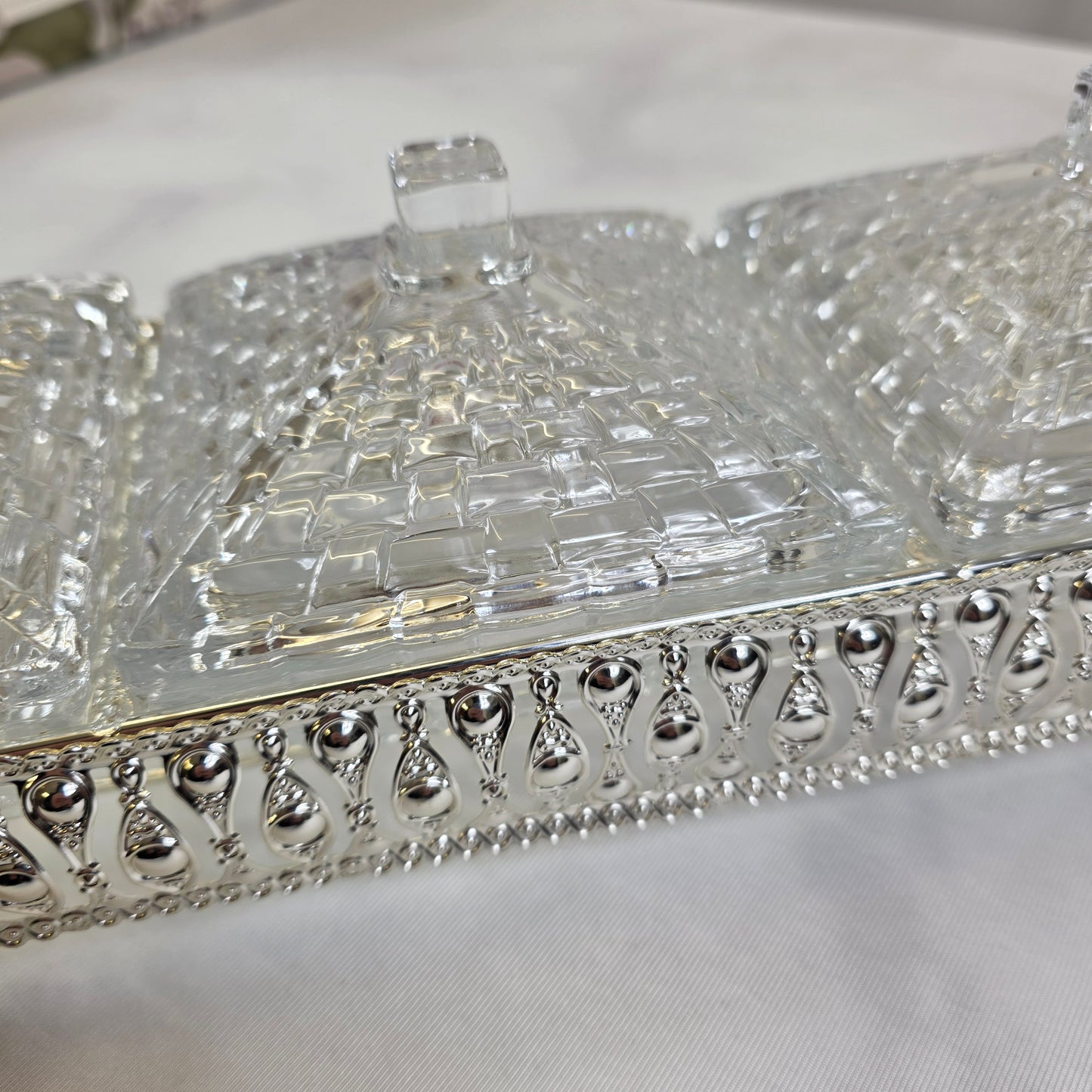 Elegante set de recipientes de cristal con base decorativa en metal plateado