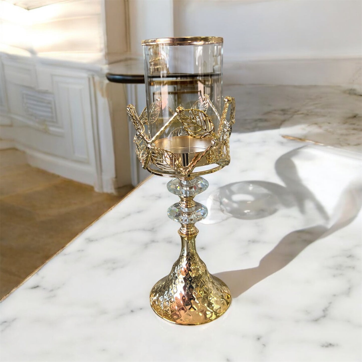 Portavelas alto dorado con copa de cristal transparente