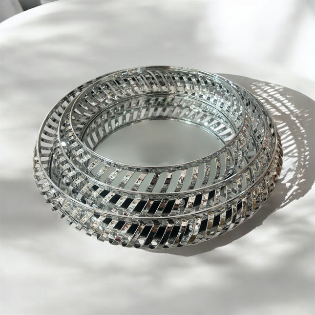 Centro de mesa redondo em metal prateado com base espelhada decorativa.